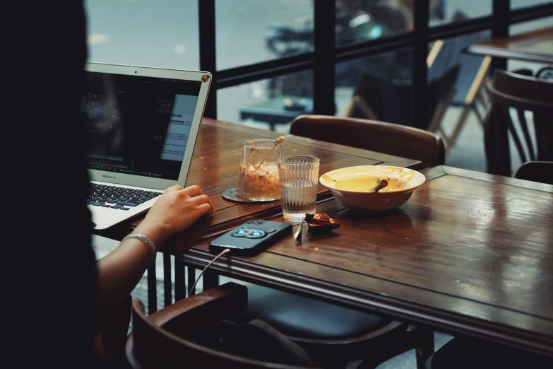 a woman sitting at a table with a laptop computer