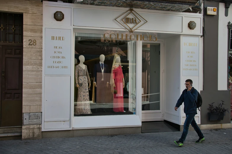 the man walks down the street past the store