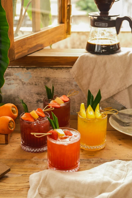 four different colored cocktails are sitting on a table