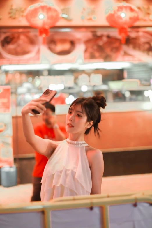 a woman takes a po with her cell phone while standing in front of a store