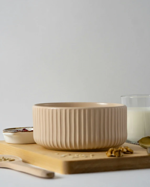 a bowl, spoon and milk sitting on a table