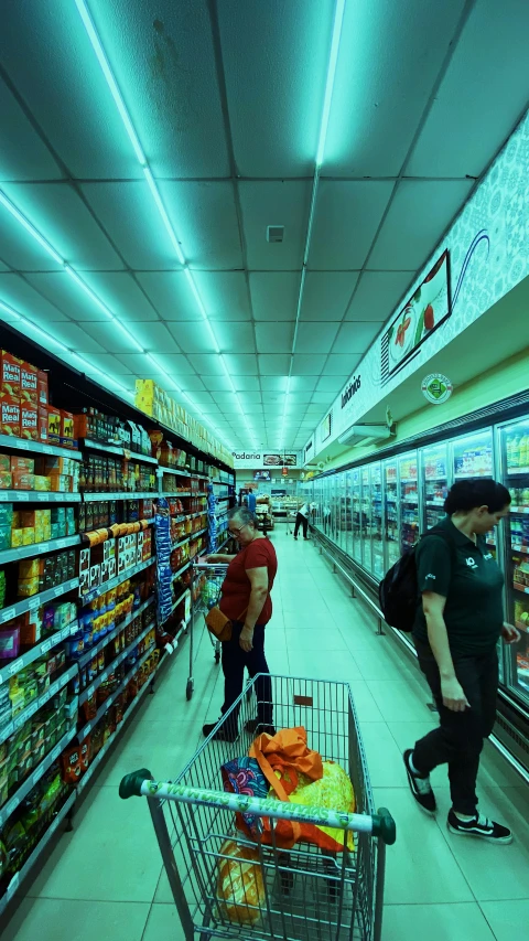 a couple of people are shopping inside of a grocery store