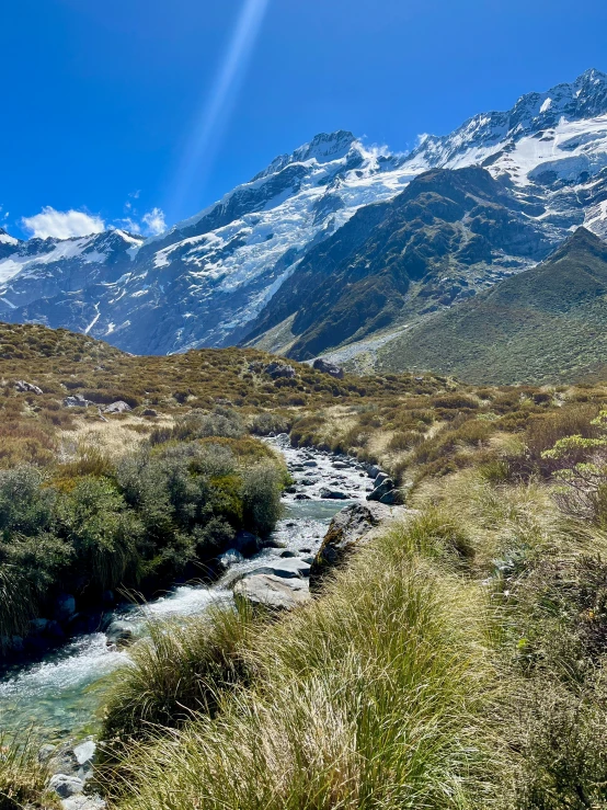 stream running in a mountain valley with grass