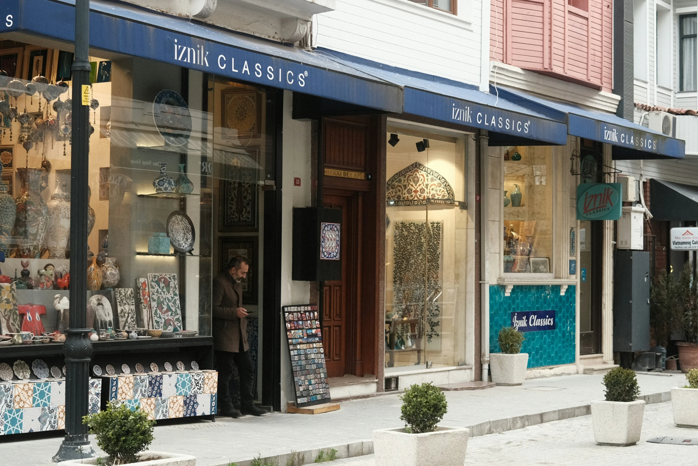 store front with windows lined with vases and a person standing in the window