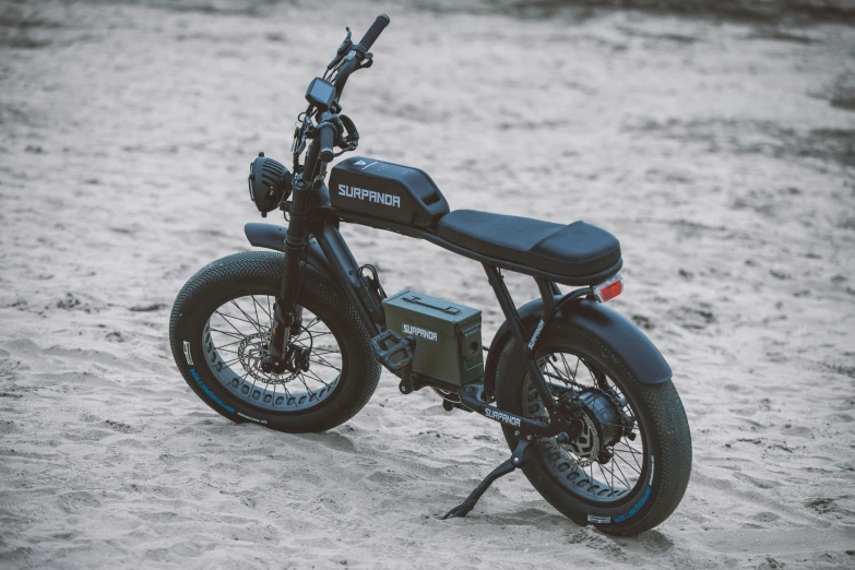 a motorcycle sitting in the sand with a chain on it