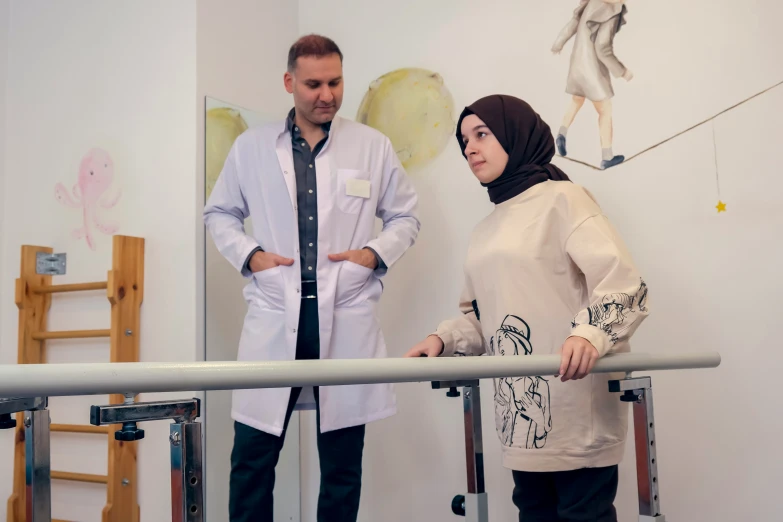 a man and woman with hijab standing next to a metal pole