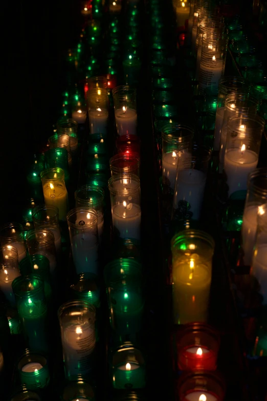 several rows of lit candles are lined up