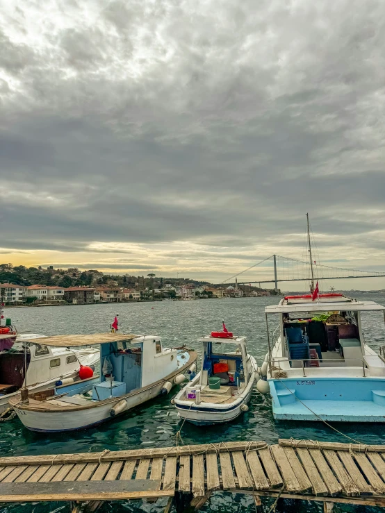 four boats docked in the water during a cloudy day