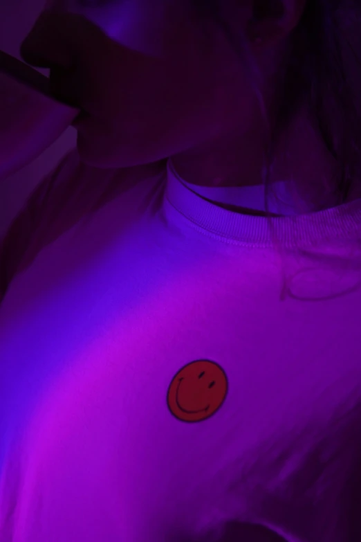 a red smiley face sticker on a purple hoodie