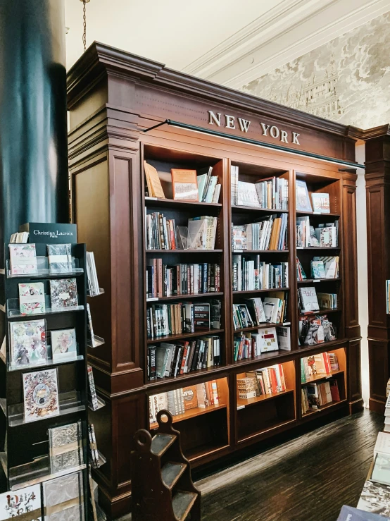 the room is full of books with people sitting at it