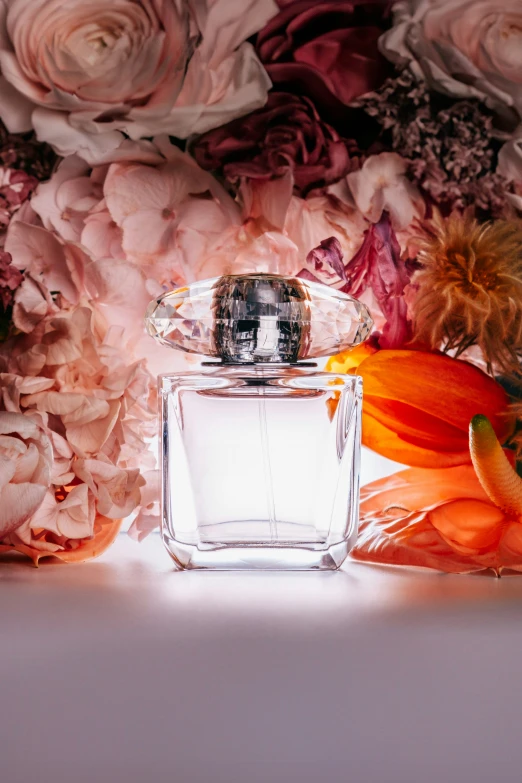 two pink flowers near a bottle of perfume