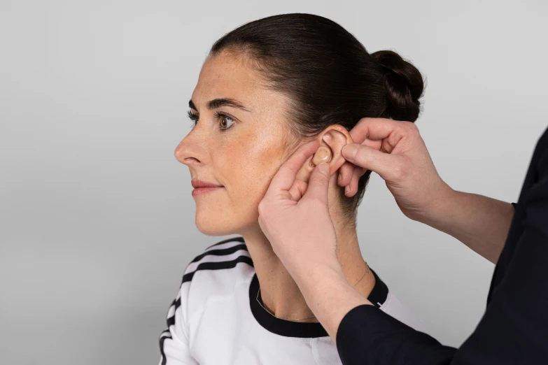 a woman is shown putting on her ear
