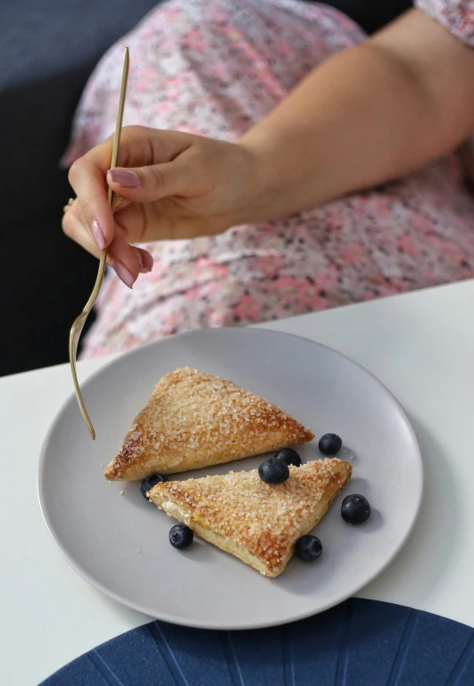 a person holding a fork over some food