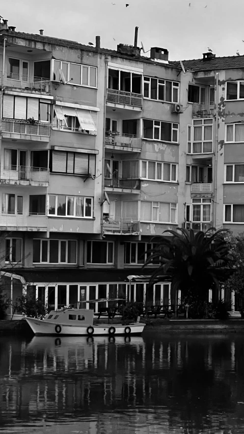 black and white pograph of boats sitting in front of a lake