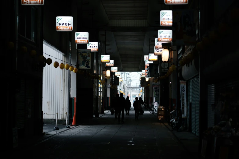 two people walk down an alley in the dark