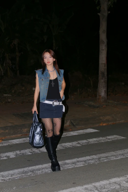 a woman is carrying a purse while walking down the road