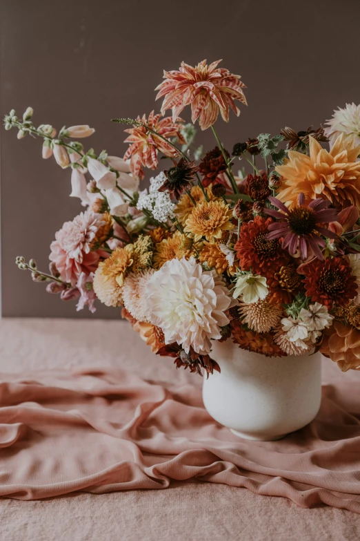 the vase with the flowers is sitting on the bed