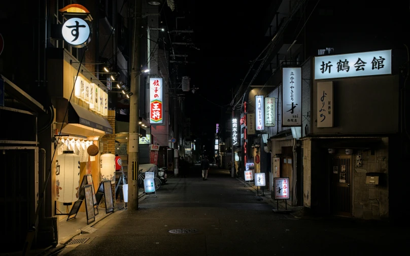 a small alley way lined with buildings at night