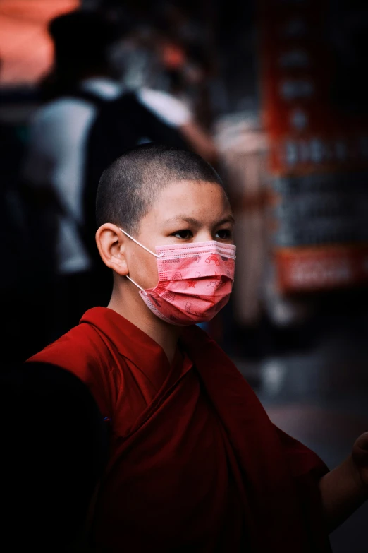 boy with a red face mask in front of a crowd