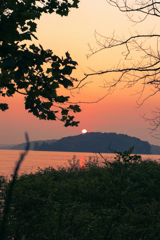 a small island in the middle of the ocean during sunset