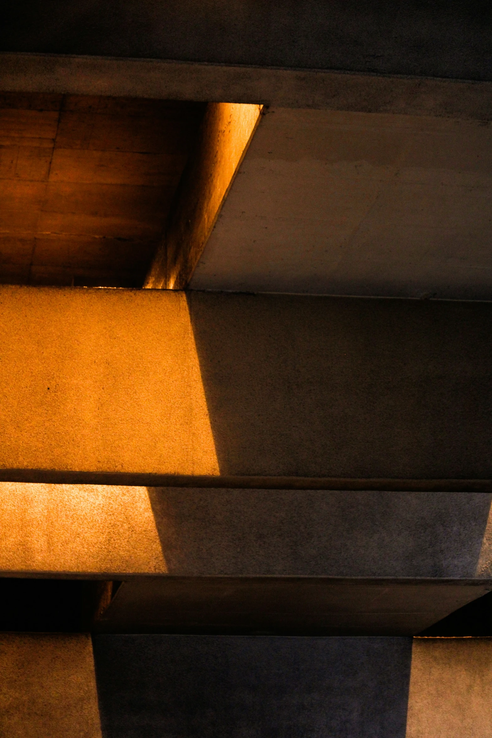 a po taken from underneath a structure that is covered in light and shadows