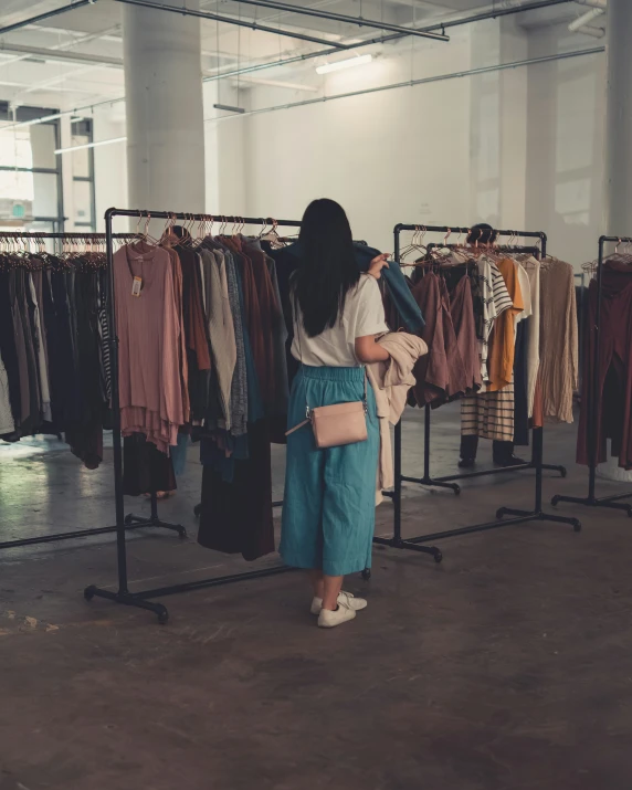 a woman is looking through clothes on display