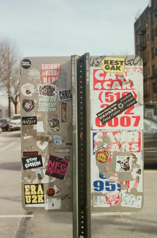 there is a street sign with various stickers all over it