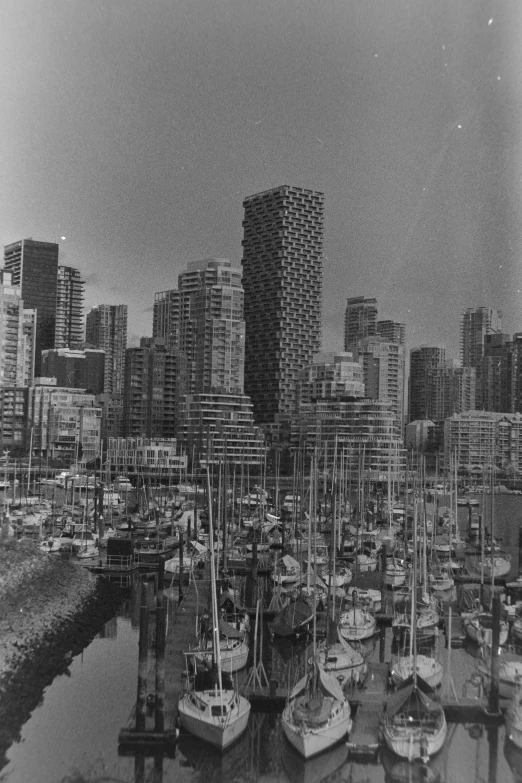 a black and white po shows the tall buildings along the waterfront in a harbor