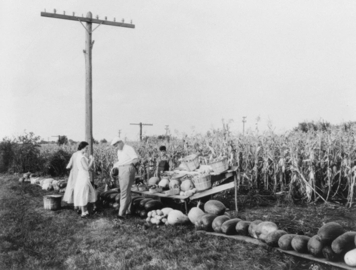 a couple of men are selling produce from a cart