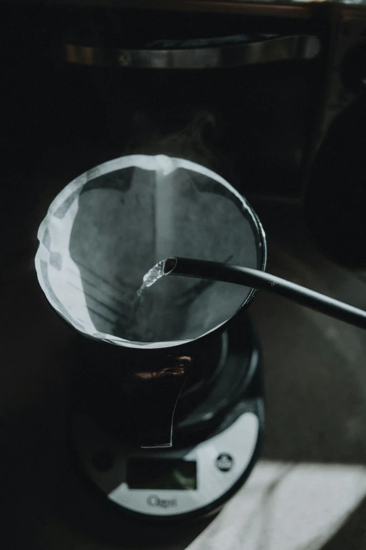 a small black coffee pot with a spoon