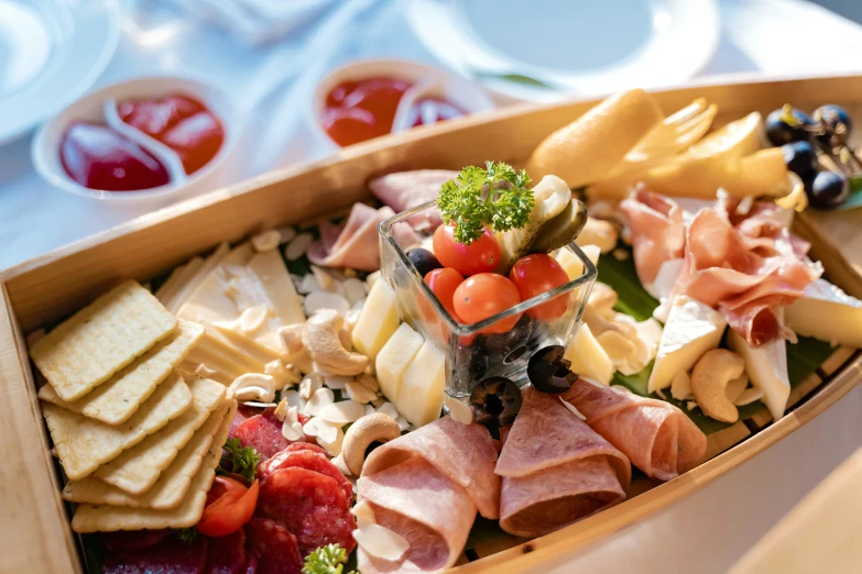 a very nicely made, wooden salad boat filled with assorted meats