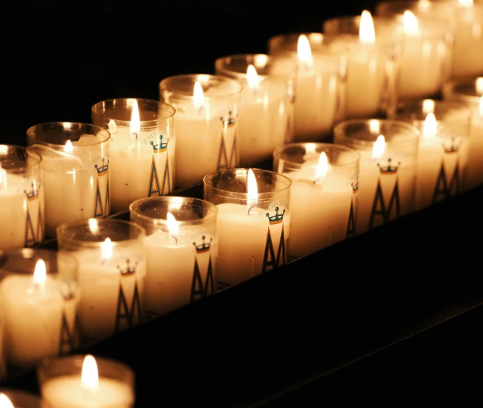 rows of lit candles sitting next to each other