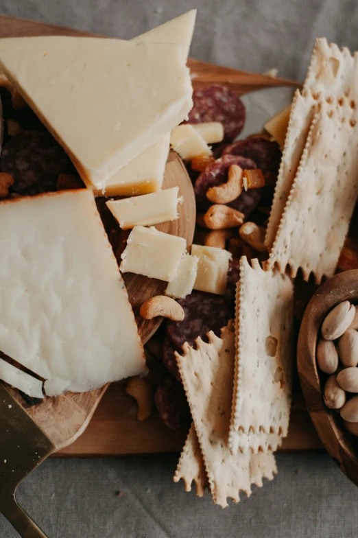 various types of cheese and nuts with a knife