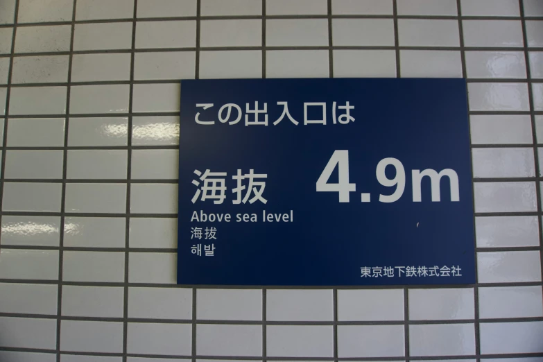 a bathroom wall with a blue and white sign