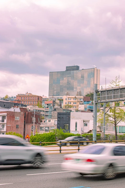 some cars driving down the road in a city