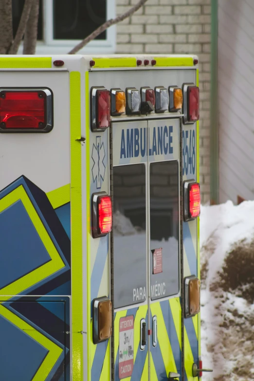 an ambulance sits parked by a snow covered hill