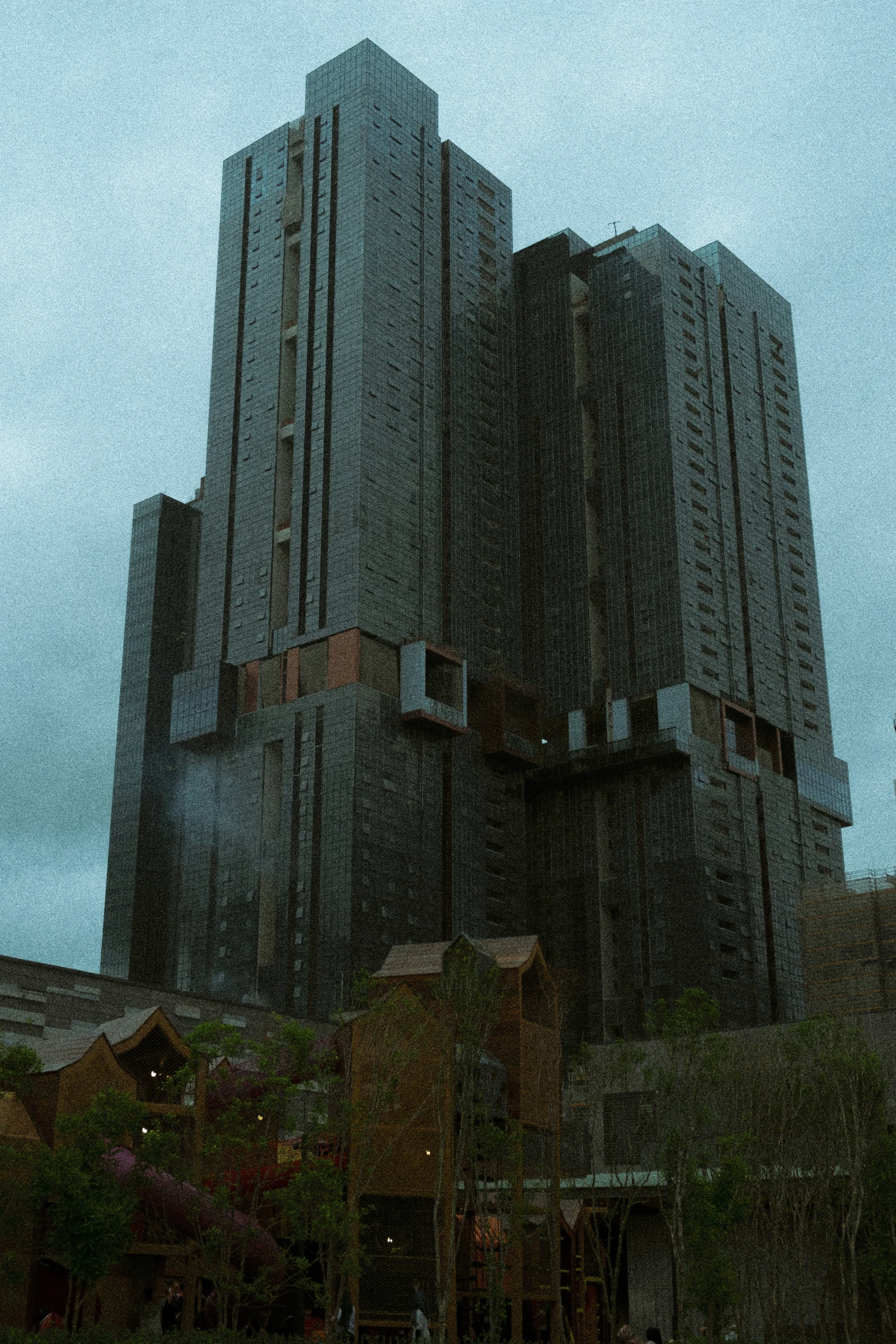 a tall building is silhouetted against an overcast sky