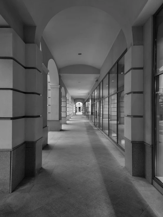 a long hallway in an empty building, leading to other rooms