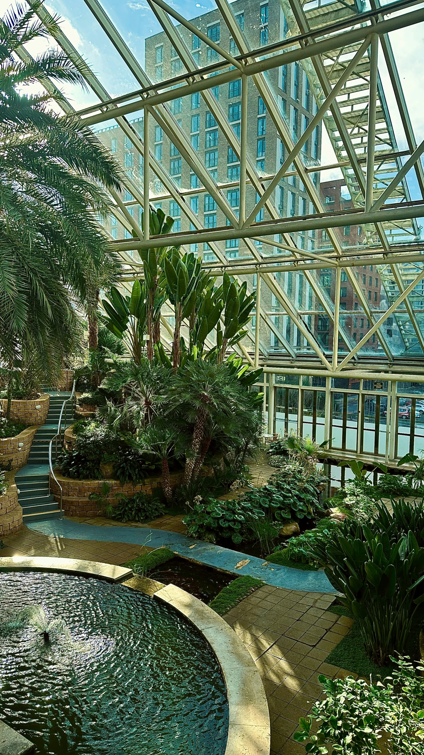 a park with a water feature and many plants around it