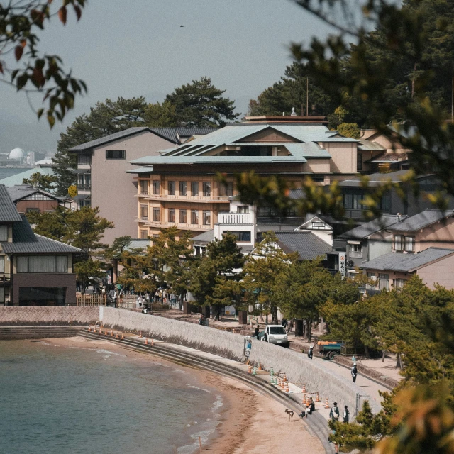 the beachfront resort has trees, sand and houses along with a walkway