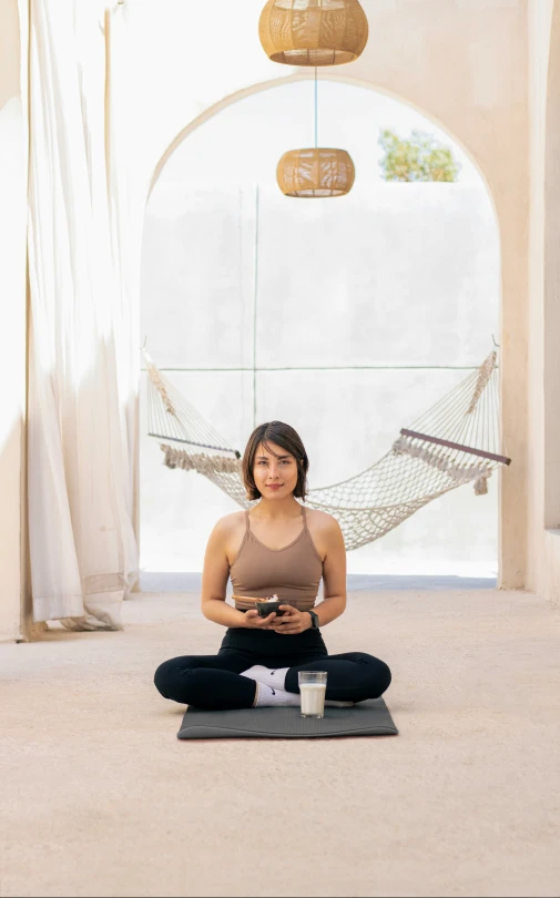 a young woman is sitting in the middle of yoga