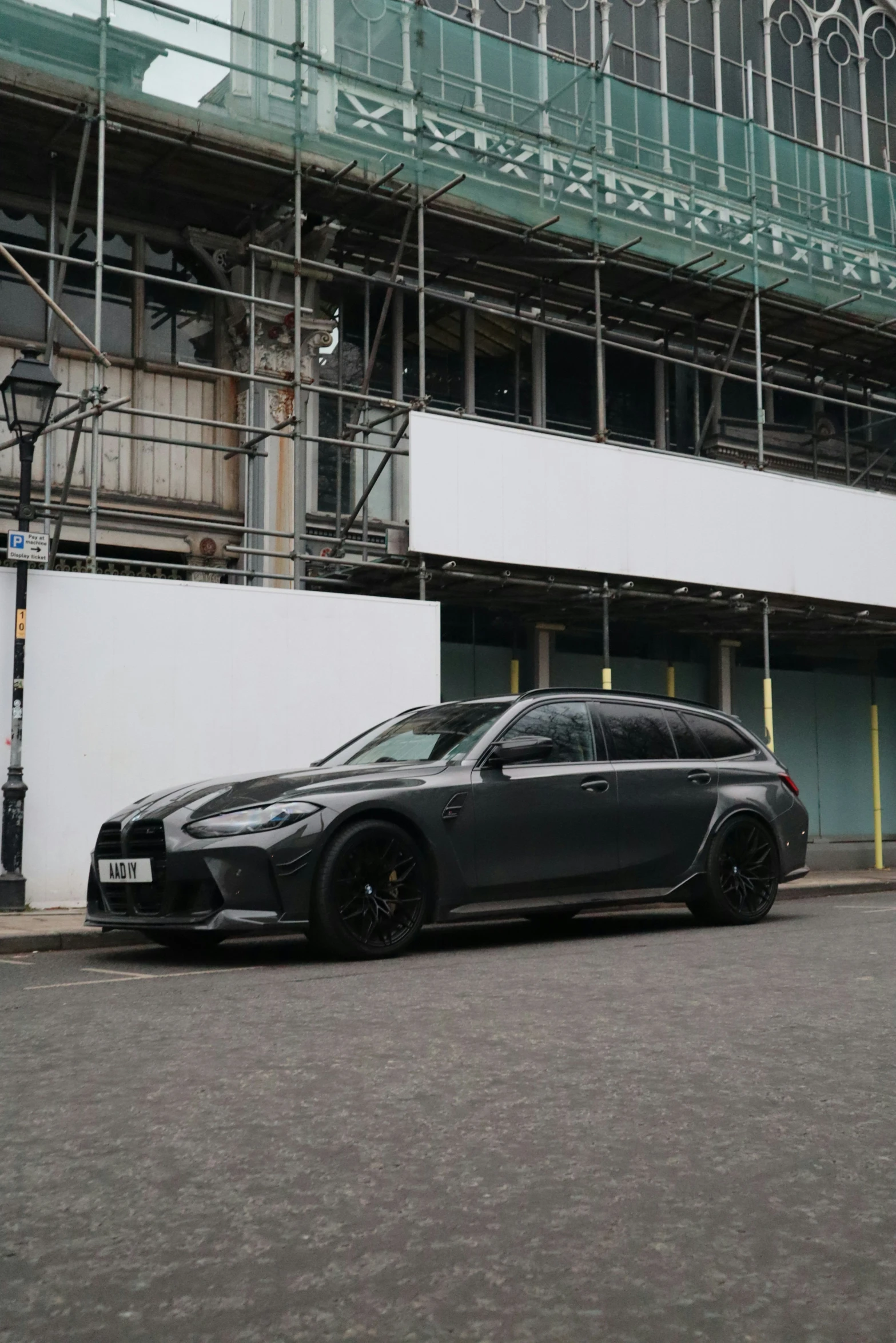 a black luxury vehicle parked outside of a building under construction