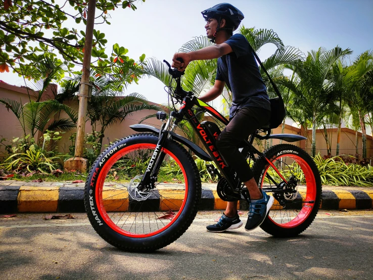 a young man on a bicycle with neon orange tire rings