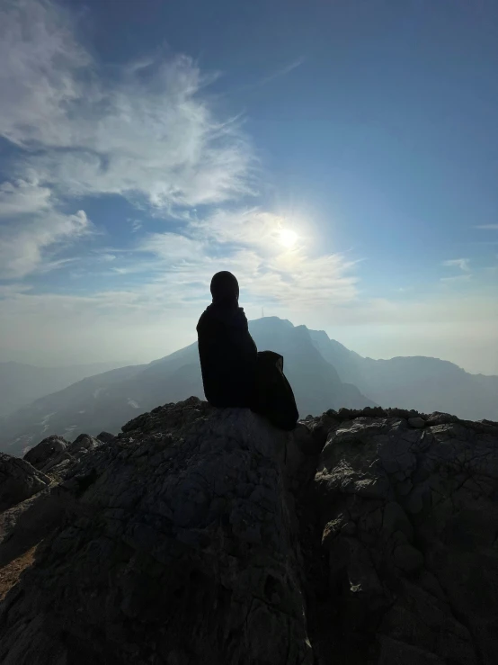 a man sitting on top of a rocky cliff