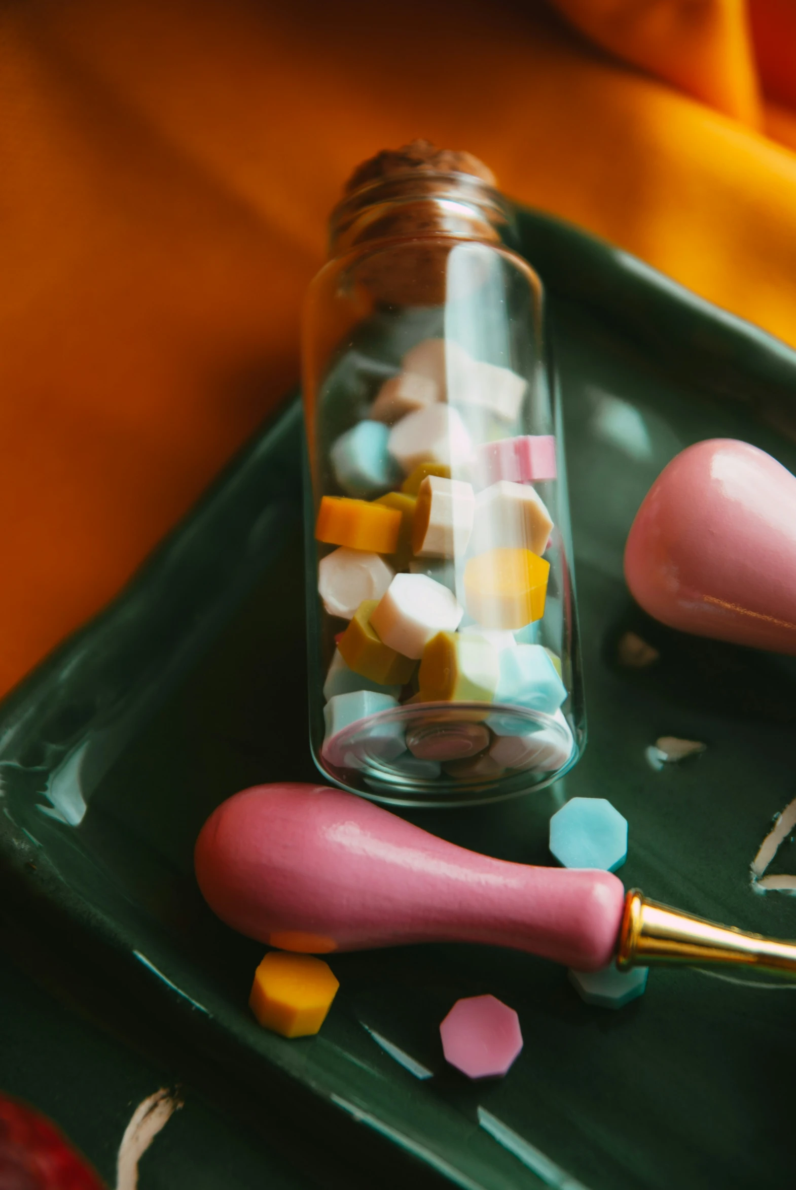 a tray filled with pink and yellow pills on top of green tray