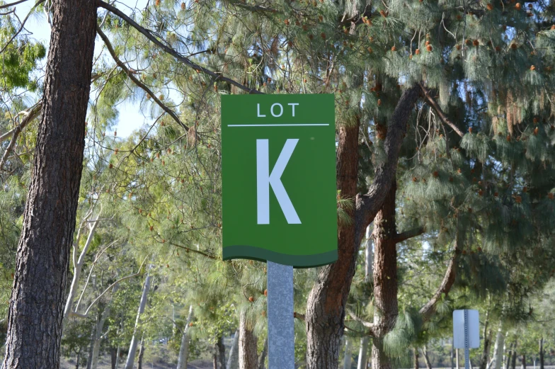 a street sign near some trees and a sky background