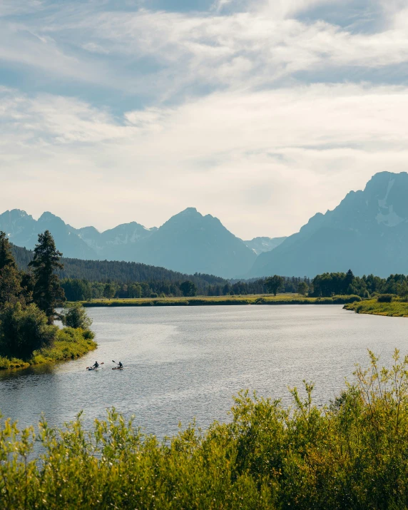 a mountain range is shown behind a large lake