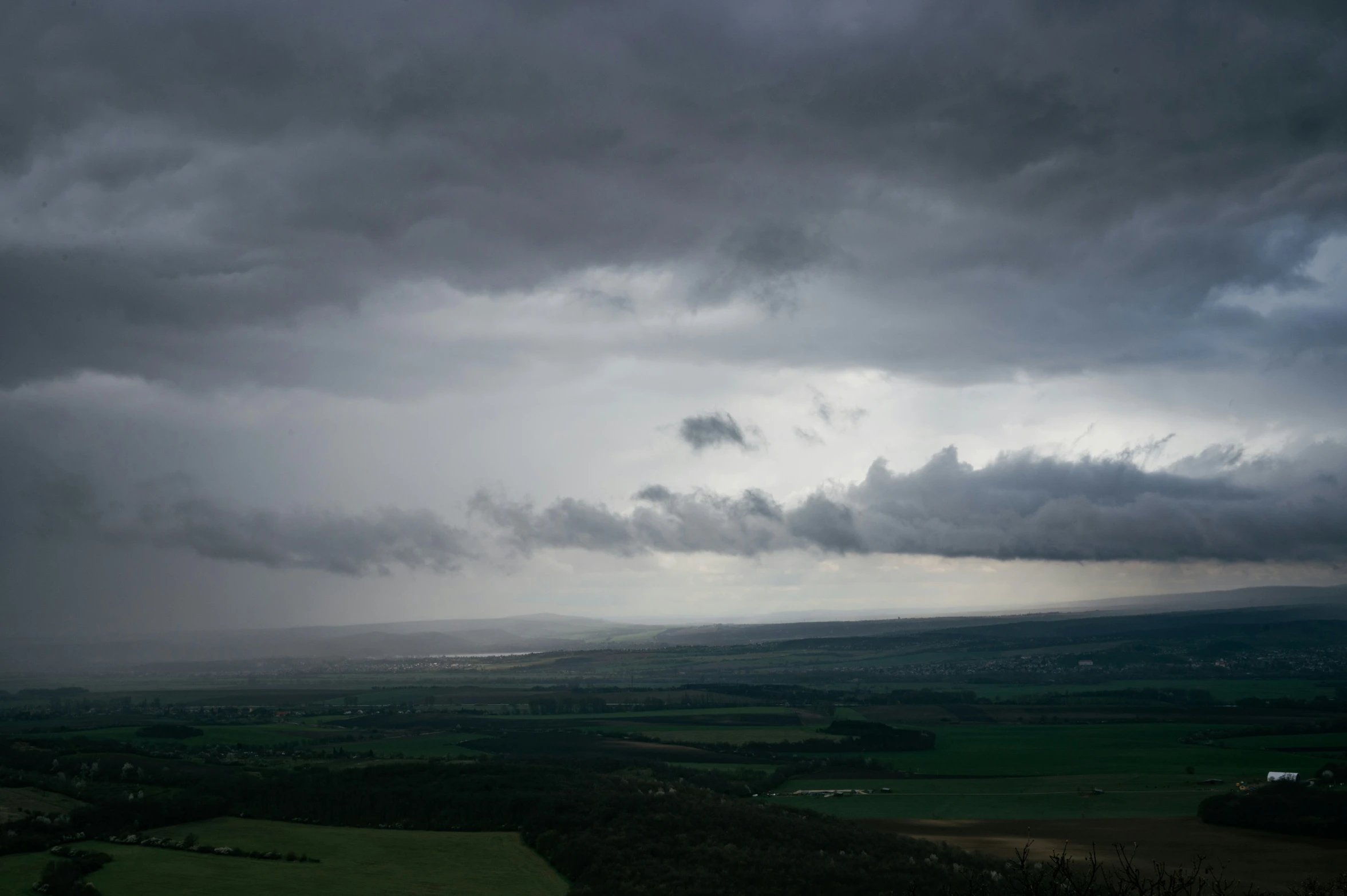 dark clouds fill the sky over farmland on a stormy day