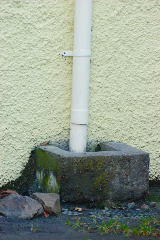 the white pipe is above a large stone block