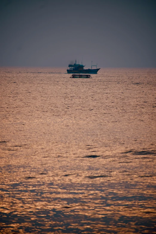 boat in the ocean at sunset as it comes down to shore